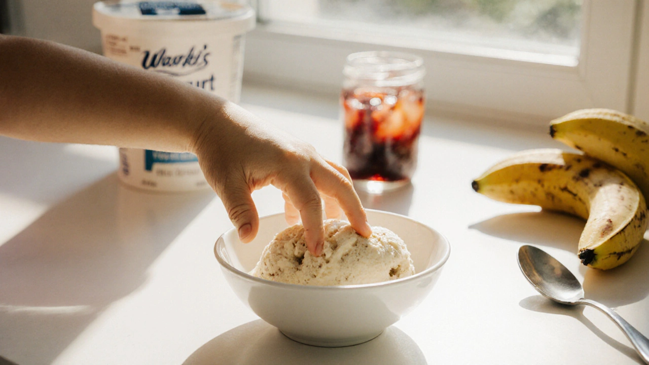 Dítě si bere domácí zmrzlinu z jogurtu s banány na slunečném kuchyňském stole.